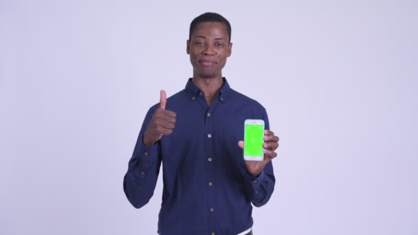 Mladý šťastný africký podnikatel ukazuje telefon a dává palec nahoru