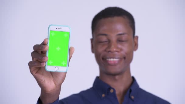 Gesicht junger glücklicher afrikanischer Geschäftsmann zeigt Handy — Stockvideo