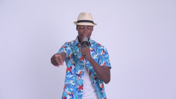 Fiatal, boldog afrikai turista férfi énekel a mikrofon