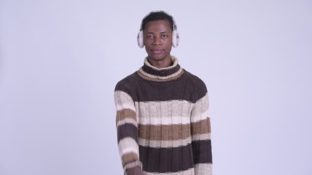 Jonge gelukkige Afrikaanse man wijzend op camera klaar voor de winter — Stockvideo