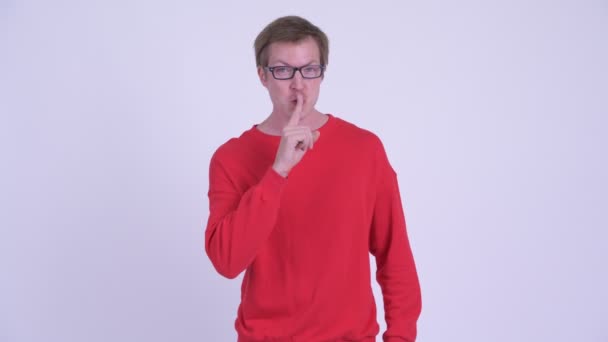 Boldog fiatal csinos férfi keres Csintalan ujjal az ajkak — Stock videók