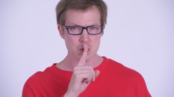 Лицо серьезного молодого человека с пальцем на губах — стоковое видео