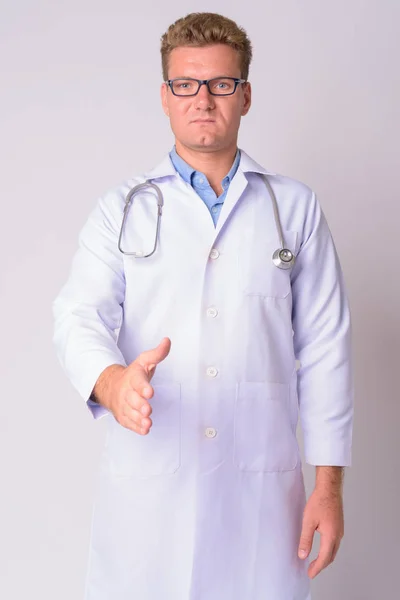 Portrait of young blonde man doctor giving handshake — Stock Photo, Image