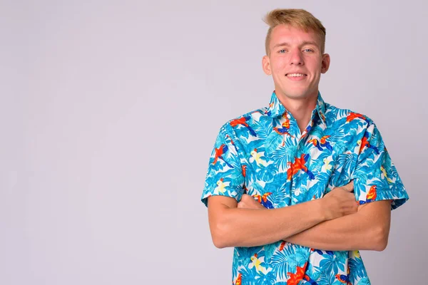 Happy young blonde tourist man smiling with arms crossed — Stock Photo, Image