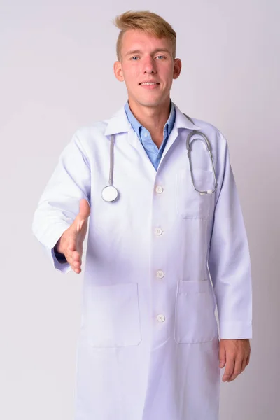Ritratto di felice giovane bionda uomo medico dare stretta di mano — Foto Stock
