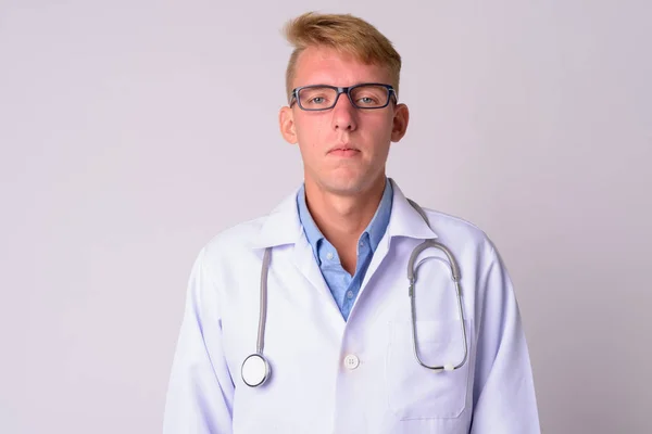 Gezicht van jonge blonde man arts het dragen van brillen — Stockfoto