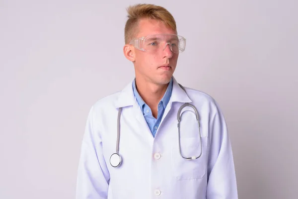 Retrato de joven rubio médico con gafas protectoras pensando —  Fotos de Stock