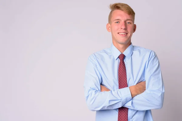 Happy young blonde businessman smiling with arms crossed — Stock Photo, Image