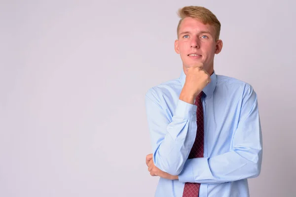 Happy young blonde businessman thinking and looking up — Stock Photo, Image