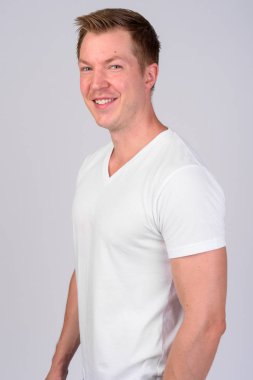 Mutlu genç yakışıklı adam kameraya bakarak profil görünümü
