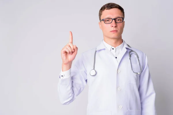 Portrait of young man doctor pointing up — Stock Photo, Image