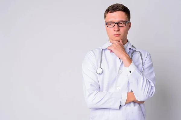 Portrait of young man doctor thinking and looking down — Stock Photo, Image