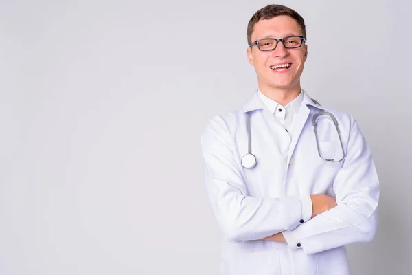 Portrait de jeune homme heureux médecin souriant avec les bras croisés — Photo