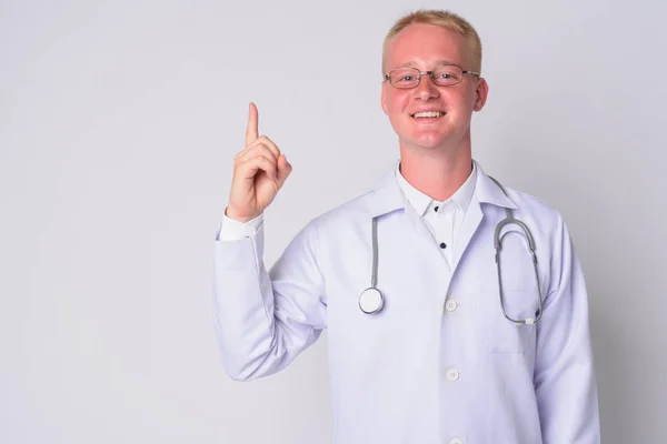 Portrait de jeune homme blond heureux médecin pointant vers le haut — Photo