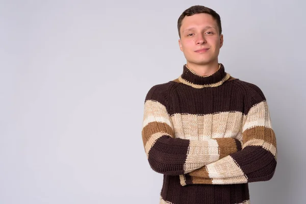 Portrait de jeune homme portant un pull col roulé avec les bras croisés — Photo