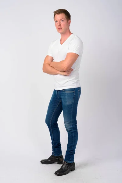 Full body shot profile view of young handsome man with arms crossed — Stock Photo, Image