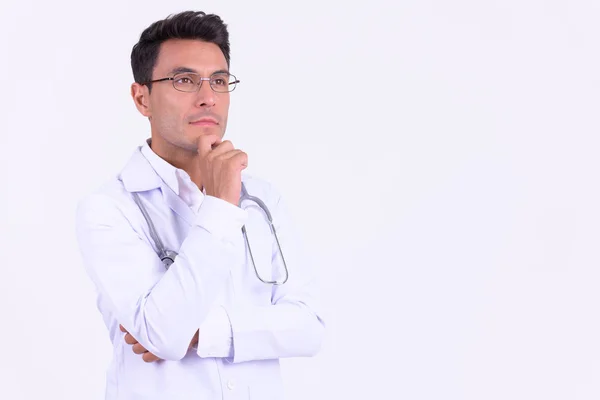 Joven guapo hispano hombre médico pensando y mirando hacia arriba —  Fotos de Stock