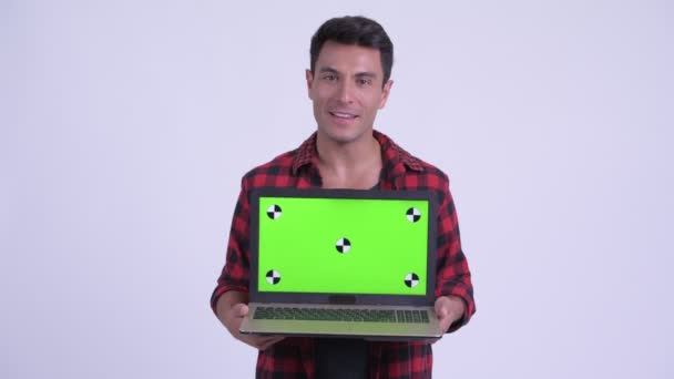 Happy young Hispanic hipster man talking while showing laptop — Stock Video