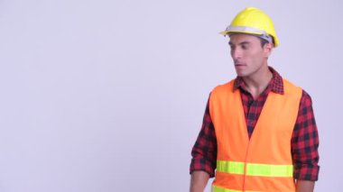 Genç mutlu Ispanyol adam inşaat işçisi bir şey dokunmadan ve başparmak vererek