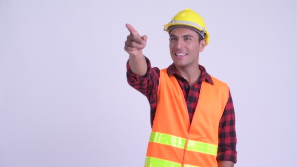 Joven feliz hispano trabajador de la construcción dirigiendo y señalando el dedo — Vídeos de Stock