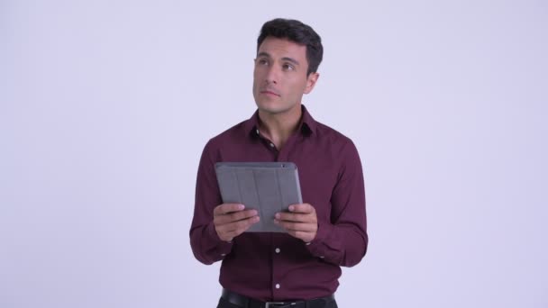Joven empresario hispano feliz pensando mientras usa tableta digital — Vídeos de Stock