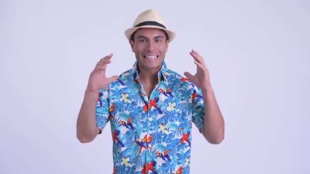 Jovem feliz turista hispânico homem apresentando algo e olhando animado — Vídeo de Stock