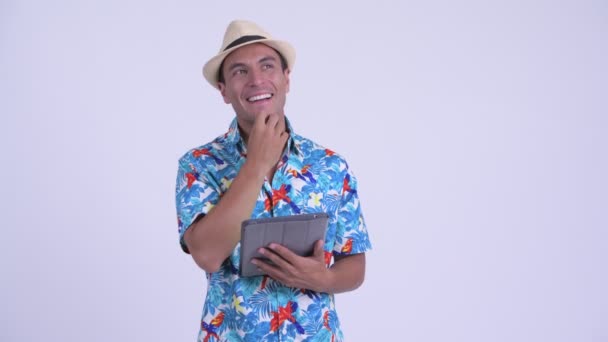 Jovem feliz turista hispânico homem pensando ao usar tablet digital — Vídeo de Stock