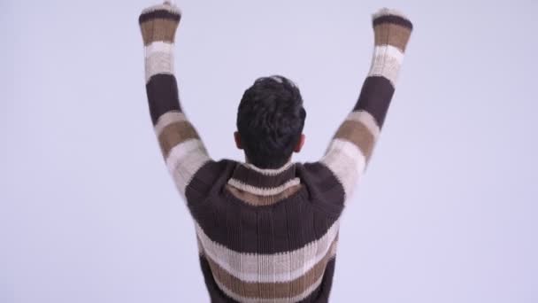 Rear view of young happy Hispanic man with fists raised ready for winter — Stock Video