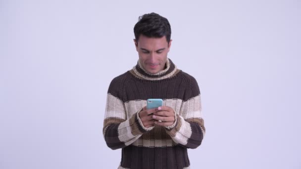 Jonge gelukkige Hispanic man met behulp van telefoon klaar voor de winter — Stockvideo