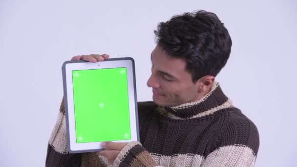 Face of young happy Hispanic man showing digital tablet ready for winter — Stock Video