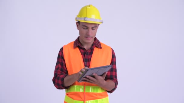 Joven feliz trabajador de la construcción hispano hablando mientras usa tableta digital — Vídeos de Stock