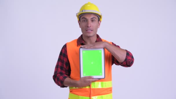 Молодой счастливый латиноамериканец строитель говорит, показывая цифровой планшет — стоковое видео