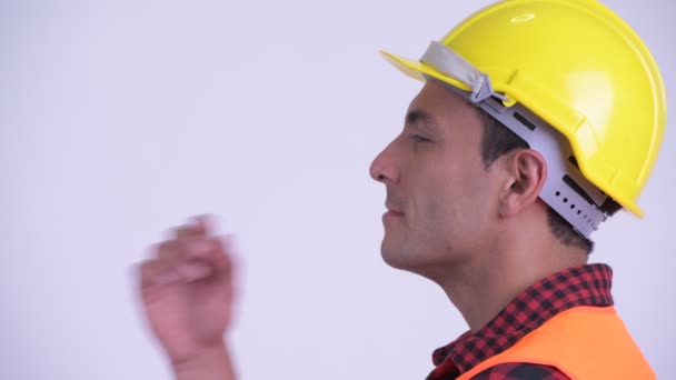 Vista del perfil de primer plano del joven feliz trabajador de la construcción hispano pensando — Vídeos de Stock