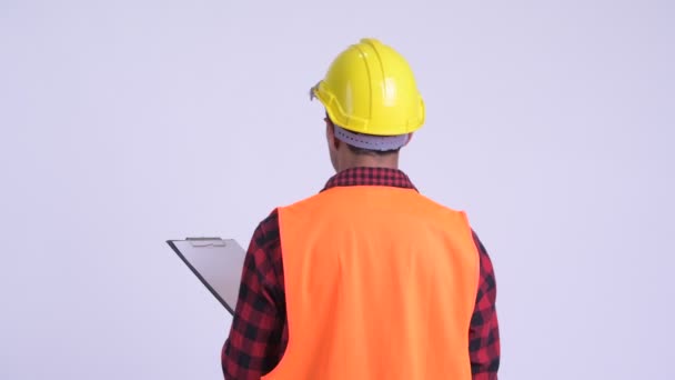 Pano üzerinde genç Ispanyol adam inşaat işçi okuma arka görünümü — Stok video