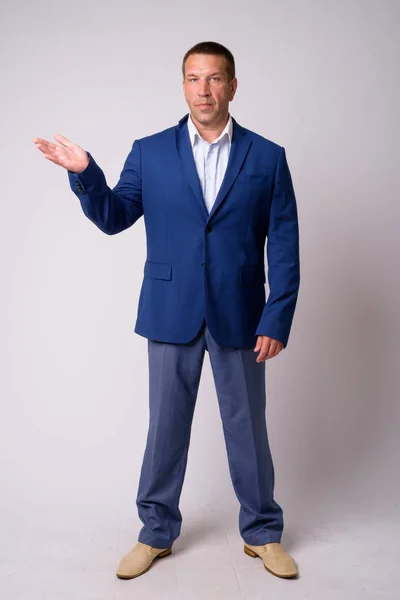 Full body shot van macho volwassen zakenman in pak iets laten zien — Stockfoto