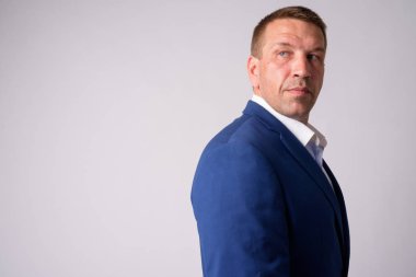 Takım elbise içinde Macho olgun işadamı profil görünümü geri bakıyor