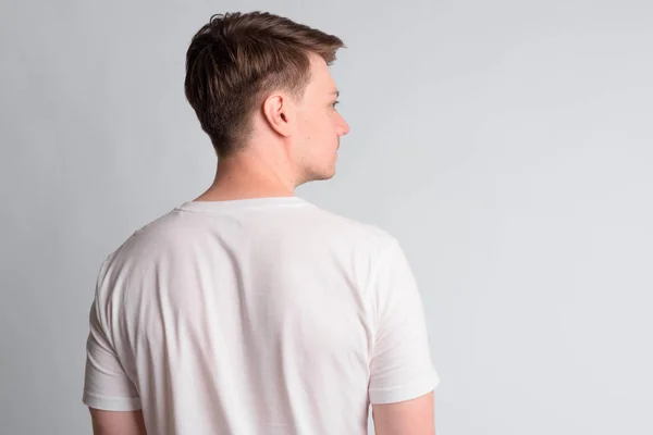 Rear view of young handsome man looking to the side — Stock Photo, Image