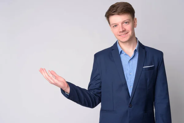 Retrato de un joven hombre de negocios feliz con traje mostrando algo —  Fotos de Stock