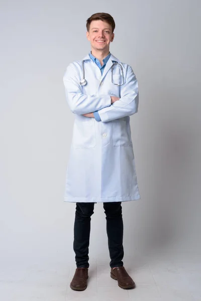 Full body shot of young happy man doctor smiling with arms crossed — Stock Photo, Image