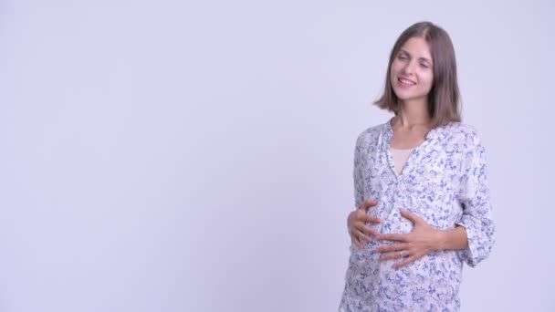 Happy young pregnant woman touching something — Stock Video