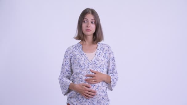 Напряженная молодая беременная женщина выглядит уставшей и скучающей — стоковое видео