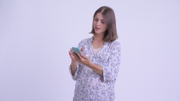Gelukkige jonge zwangere vrouw met telefoon — Stockvideo