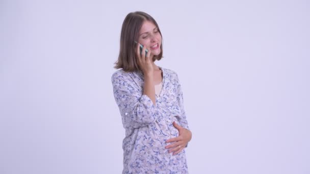 Happy young pregnant woman talking on the phone — Stock Video