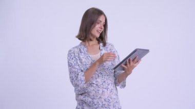 Dijital tablet kullanırken mutlu genç hamile kadın düşünme