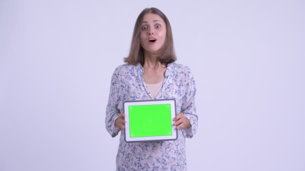 Gelukkige jonge zwangere vrouw toont digitale Tablet en op zoek verrast — Stockvideo
