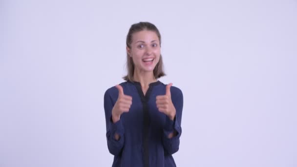 Happy young beautiful businesswoman giving thumbs up and looking excited — Stock Video