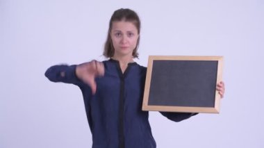 Genç ciddi işkadını tahta tutarak ve aşağı başparmak veren
