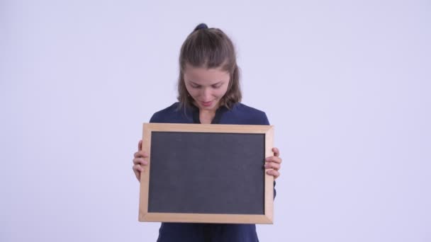 Lycklig ung vacker affärs kvinna som innehar svarta tavlan och ser förvånad — Stockvideo