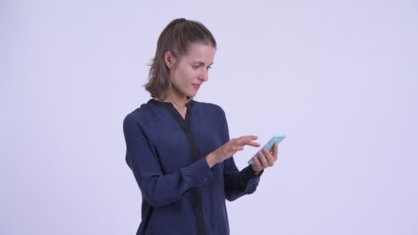 Счастливая молодая красивая бизнесвумен, использующая телефон и получающая хорошие новости — стоковое видео