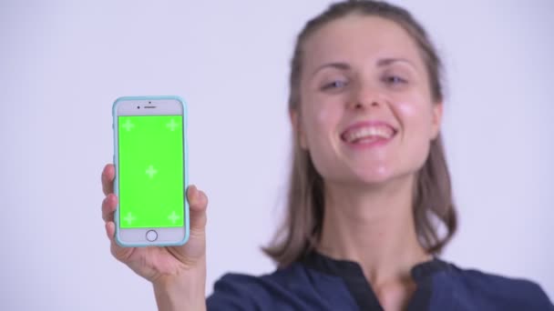 Rostro de feliz joven hermosa mujer de negocios mostrando el teléfono — Vídeos de Stock